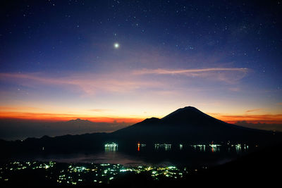 Silhouette mountains against sky at night