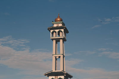 Low angle view of cross on building against sky