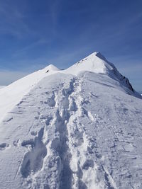 Snow covered mountain against blue sky