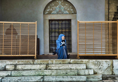 Full length of woman standing by window of building