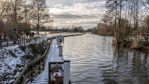 Scenic view of frozen canal against sky during winter