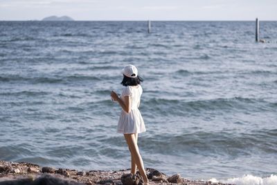 Rear view of woman standing on beach