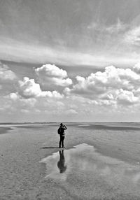 Full length of woman standing on beach against sky