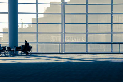 Rear view of man sitting on chair in city