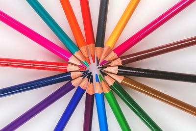 Directly above shot of multi colored pencils on white table