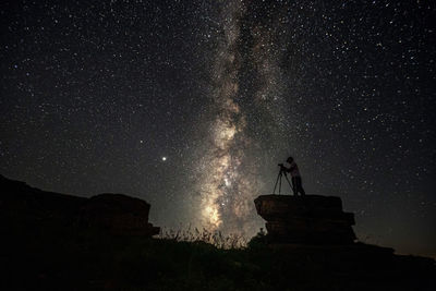 Low angle view of silhouette fireworks against sky at night