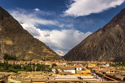 Buildings in town against cloudy sky