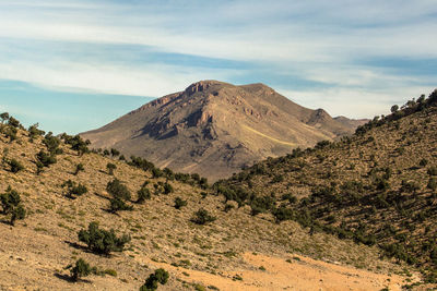 Scenic view of dry atlas mountains against a cloudy sky, ifrane, morocco