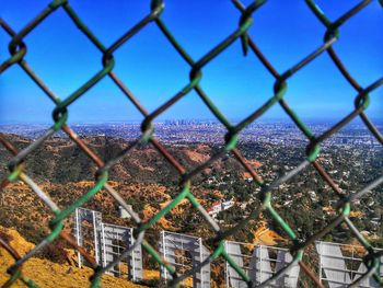 Full frame shot of chainlink fence against blue sky