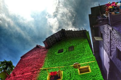 Exterior of multi colored built structure against cloudy sky