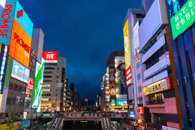 Illuminated street amidst buildings in city at night