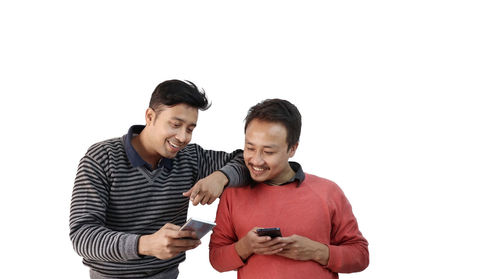 Young man using smart phone against white background