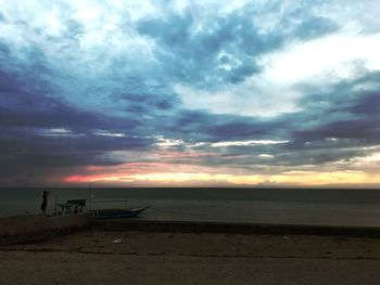 Scenic view of beach against dramatic sky