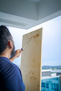 Rear view of man standing against built structure