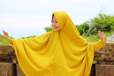 Mid adult man standing on yellow temple against sky
