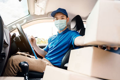 Portrait of young man using phone while sitting on seat