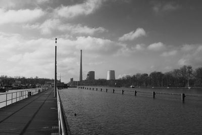 City at waterfront against cloudy sky