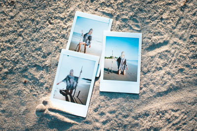 High angle view of photographs on sand