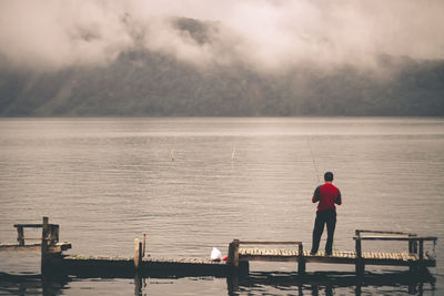 Rear view of man fishing in lake