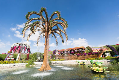 Fountain in park against blue sky