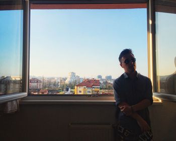 Man looking at cityscape seen through glass window