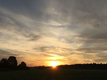 Scenic view of silhouette field against sky during sunset