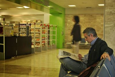 Side view of man sitting in illuminated room