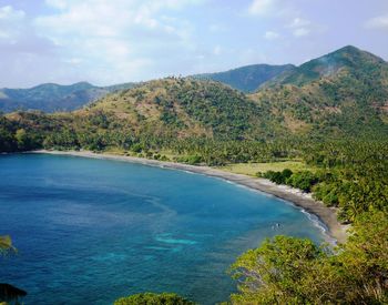 Scenic view of sea and mountains against sky