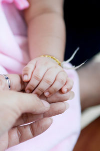 Close-up of woman holding baby hand