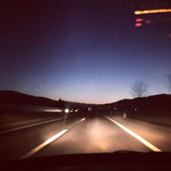 Cars on road against sky at night