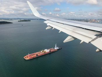 High angle view of airplane flying over sea against sky