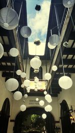 Low angle view of illuminated lanterns hanging against sky