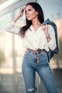 Fashionable young woman looking away while standing in city