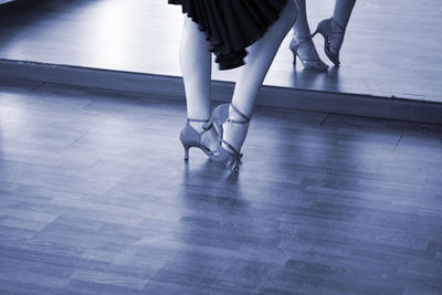 Low section of woman dancing on tiled floor