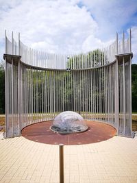 Wooden railing by plants against sky