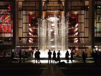 People in illuminated building at night