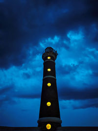 Low angle view of illuminated tower against sky at dusk