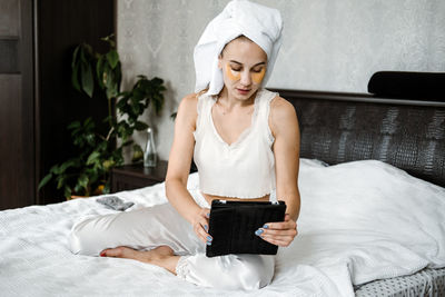 Beauty blogger, vlogger, influencer. young woman in pajamas, towel on her head and with cosmetic