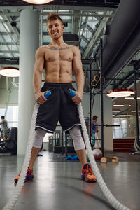 Portrait of shirtless man exercising in gym