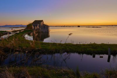 Scenic view of lake against sky during sunset