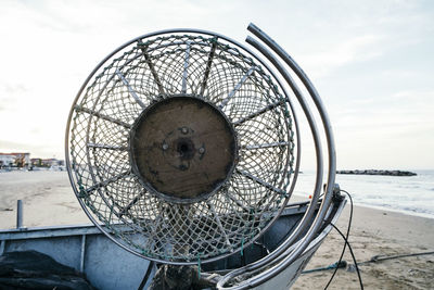 Old electric fan on boat at beach against sky