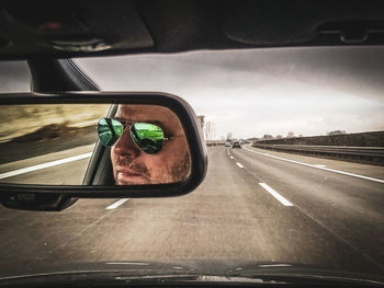 Reflection of man in car mirror
