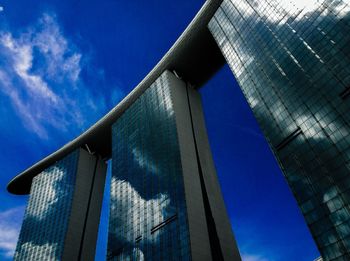 Low angle view of modern building against blue sky