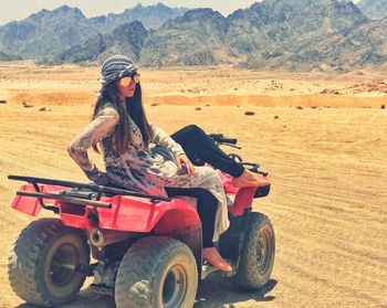 Young woman sitting on quad bike