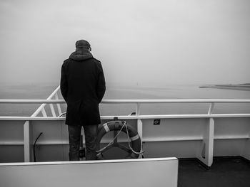 Rear view of man looking at sea against sky