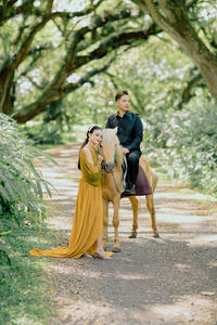 Rear view of woman sitting on rock
