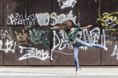 Full length of person with graffiti on wall