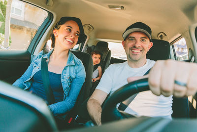 Portrait of happy friends sitting in car