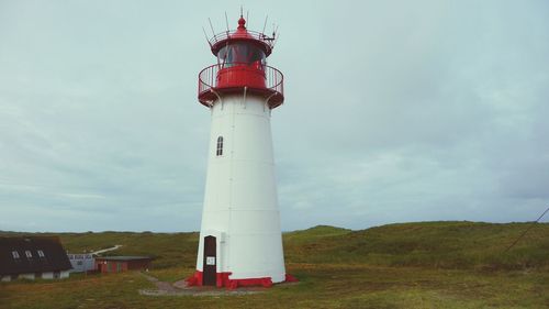 Lighthouse by sea against sky