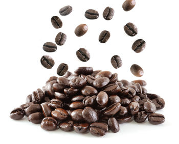 High angle view of coffee beans against white background